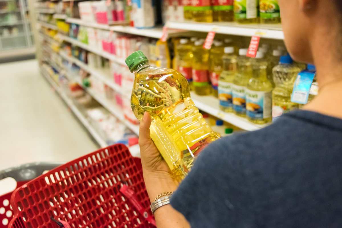 Persona acquista l'olio al supermercato