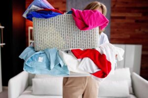 Donna con una grande scatola di vestiti in mano