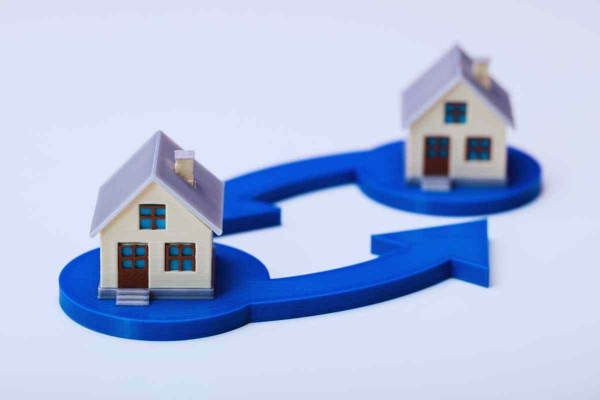 Modellini di casa e frecce che indicano lo scambio