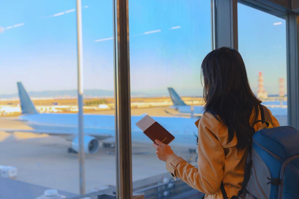 Ragazza in aeroporto che guarda la pista