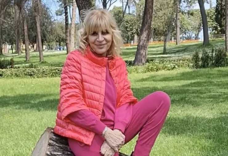 Gemma galgani poggiata su un tronco all'interno di uno splendido giardino