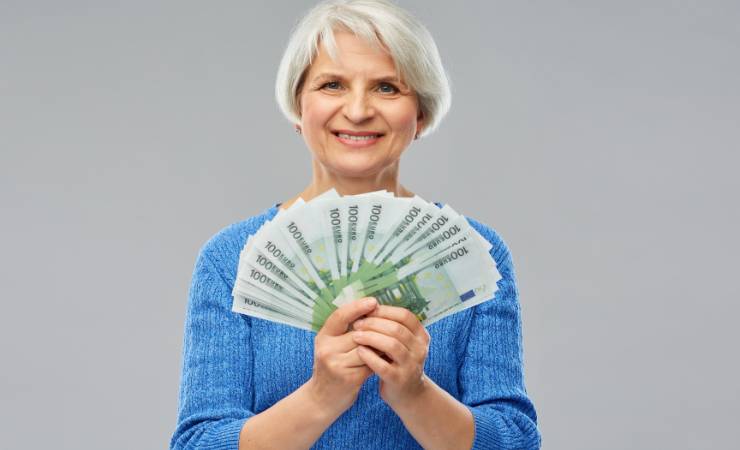 Donna anziana con un ventaglio di banconote da 100 euro