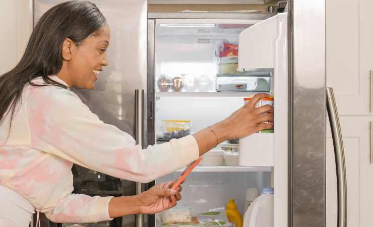 Donna con il frigo aperto