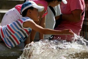 Bambino si rinfresca ad una fontana