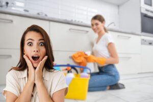 donna sorpresa e un'altra che pulisce casa