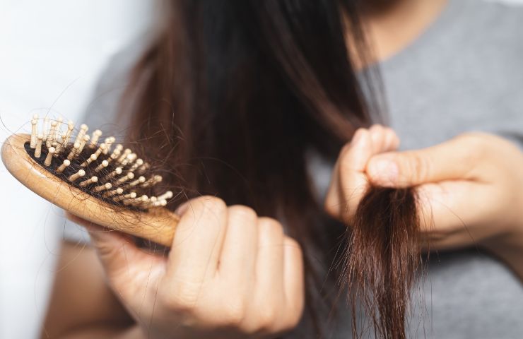donna che spazzola i capelli che cadono