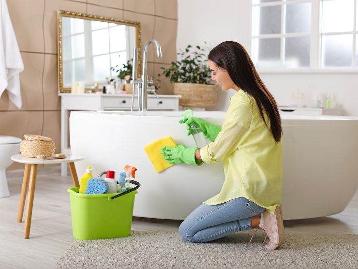 donna in bagno che pulisce vasca