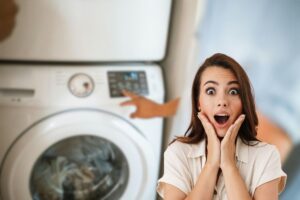 uomo che aziona lavatrice e donna sorpresa