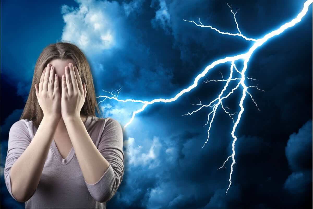 Ragazza con mani sul viso e lampo/fulmine dietro di lei