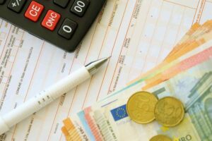 penna su foglio, soldi e calcolatrice