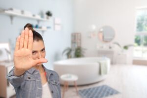 bagno sullo sfondo e donna che fa stop con le mani
