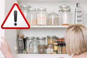 Donna che apre credenza e simbolo attenzione