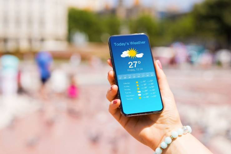 Donna con cellulare in mano che guarda meteo