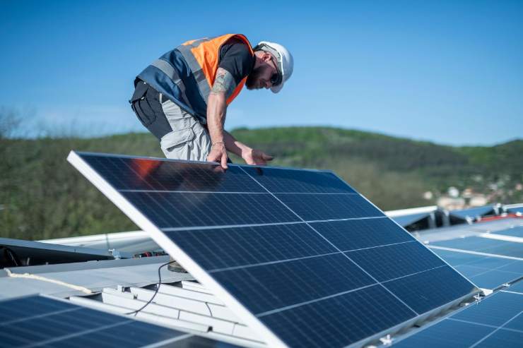 Tecnico che mette pannello fotovoltaico