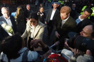 Meghan e Harry circondati da giornalisti e curiosi