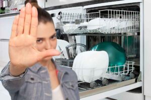 lavastoviglie aperta e donna con mano gesto stop