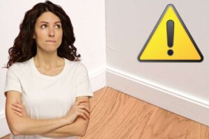 Angolo di casa, donna dubbiosa e triangolo giallo per attenzione