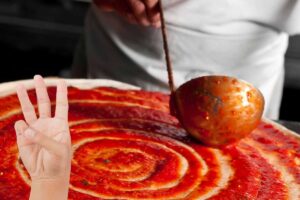 Pizza rossa e mano con numero tre