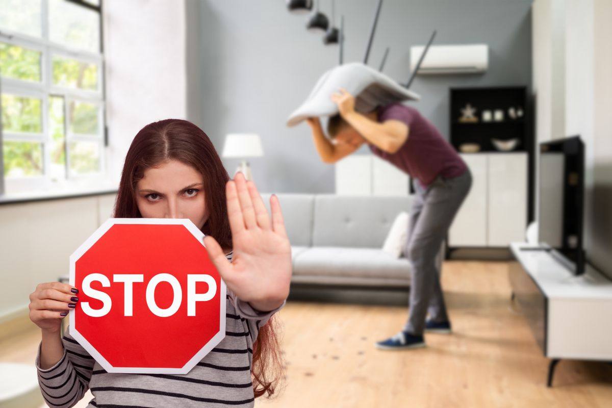 uomo che tenta di scacciare gli scarafaggi da casa e donna con cartello stop
