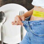 Piatto vuoto, donna che mostra dimagrimento