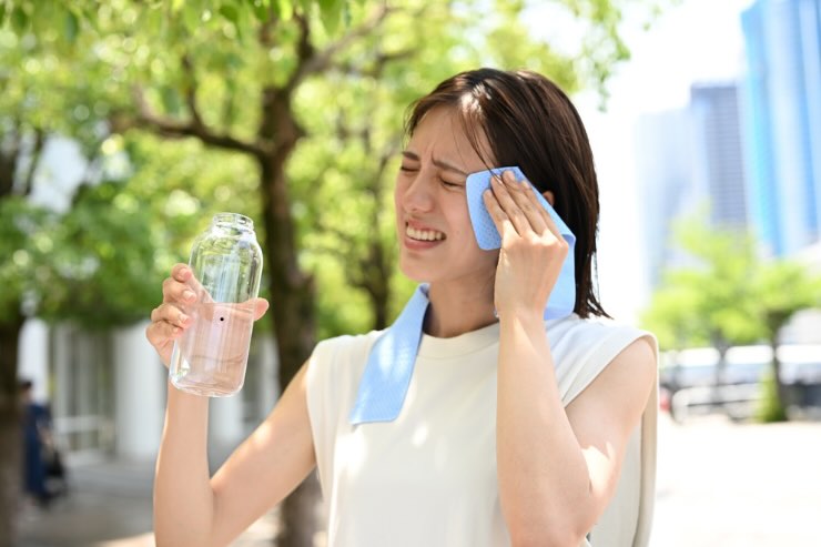 donna con straccio per asciugare sudore e bottiglia di acqua