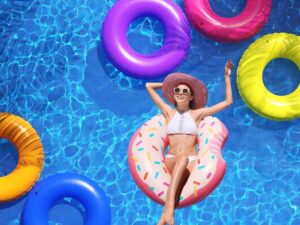 Donna in piscina dentro ciambella colorata