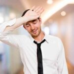 Uomo con mano sulla testa ma sollevato