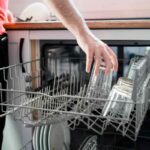 donna che carica bicchieri e piatti nella lavastoviglie