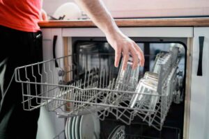 donna che carica bicchieri e piatti nella lavastoviglie