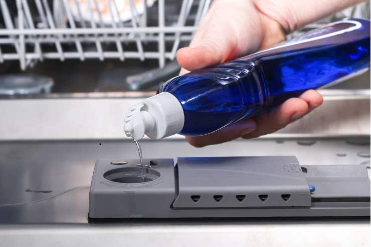 versare liquido blu nella lavastoviglie
