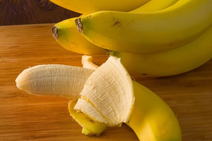Banane e in primo piano banana sbucciata per metà