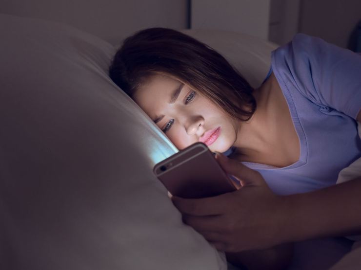 Donna che guarda cellulare nella n otte