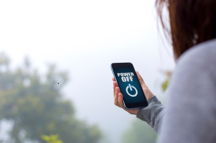 donna con smartphone in mano con power off